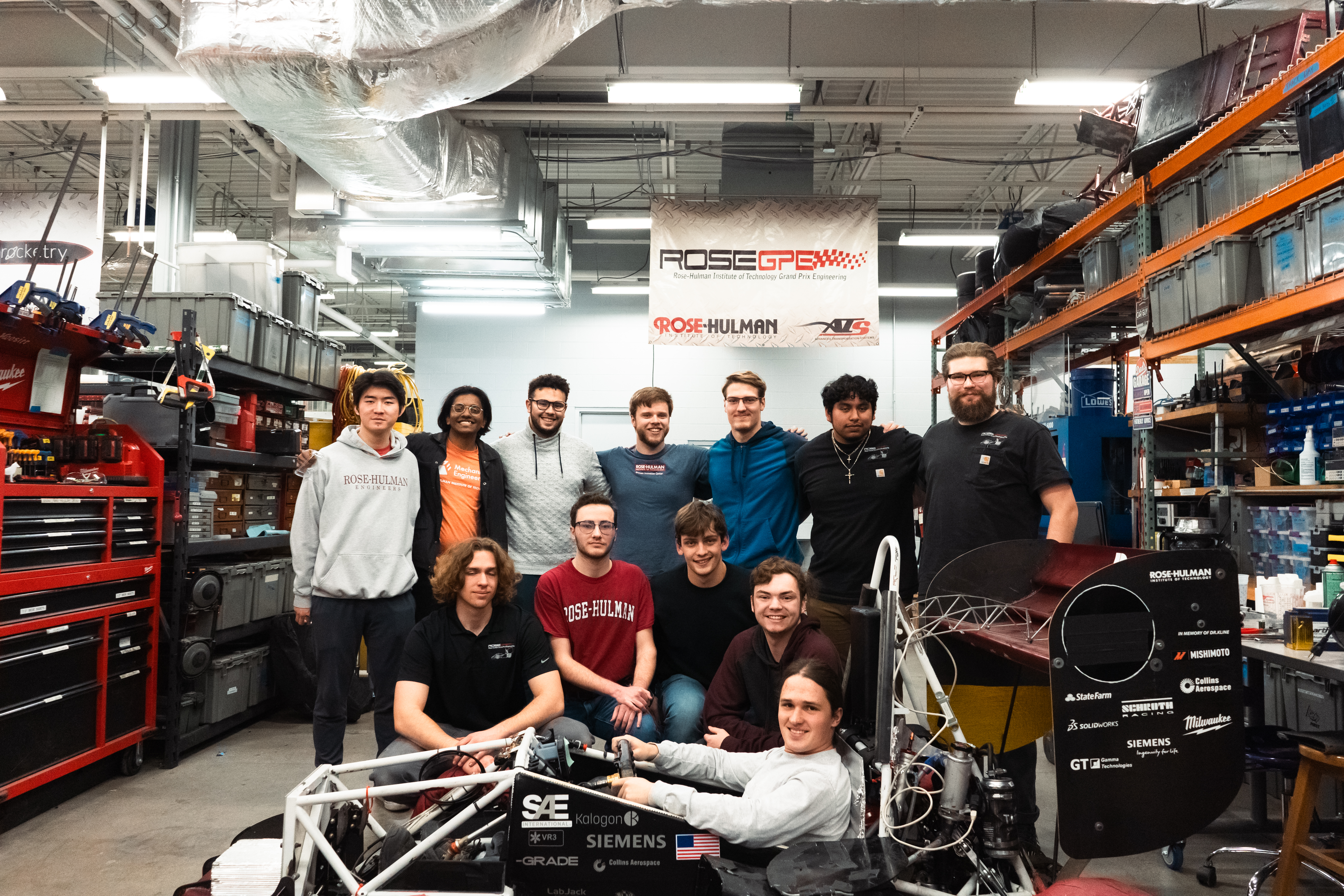 GPE students stand beside racecar they built.